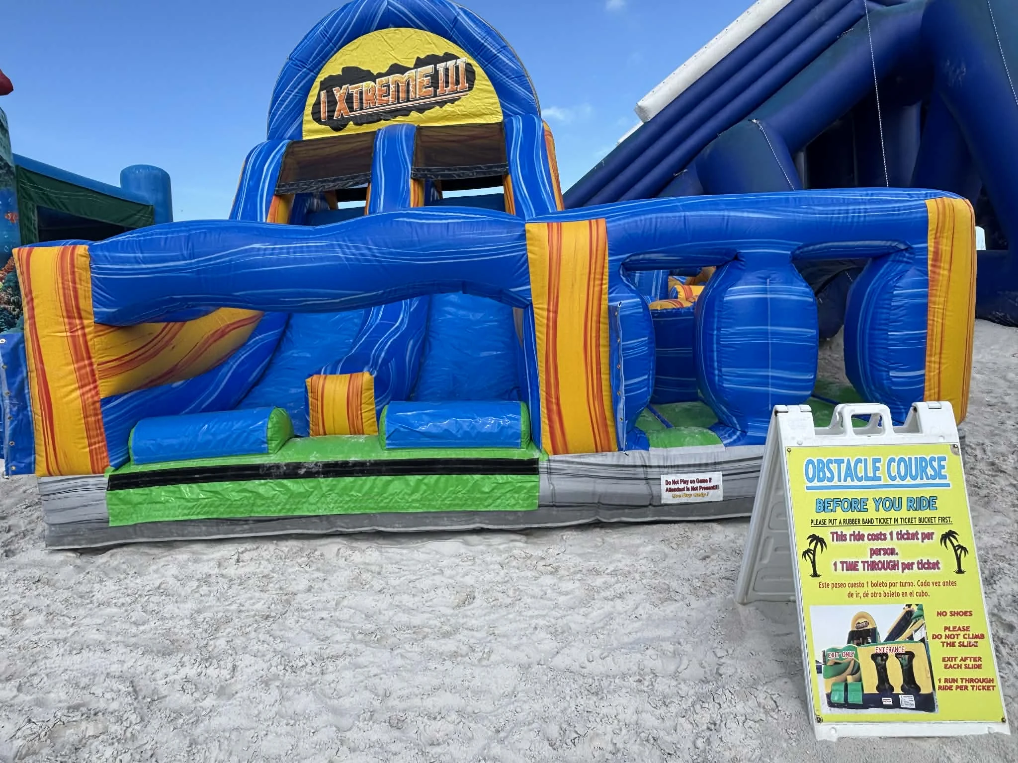 Blue and green inflatable obstacle course on the sand