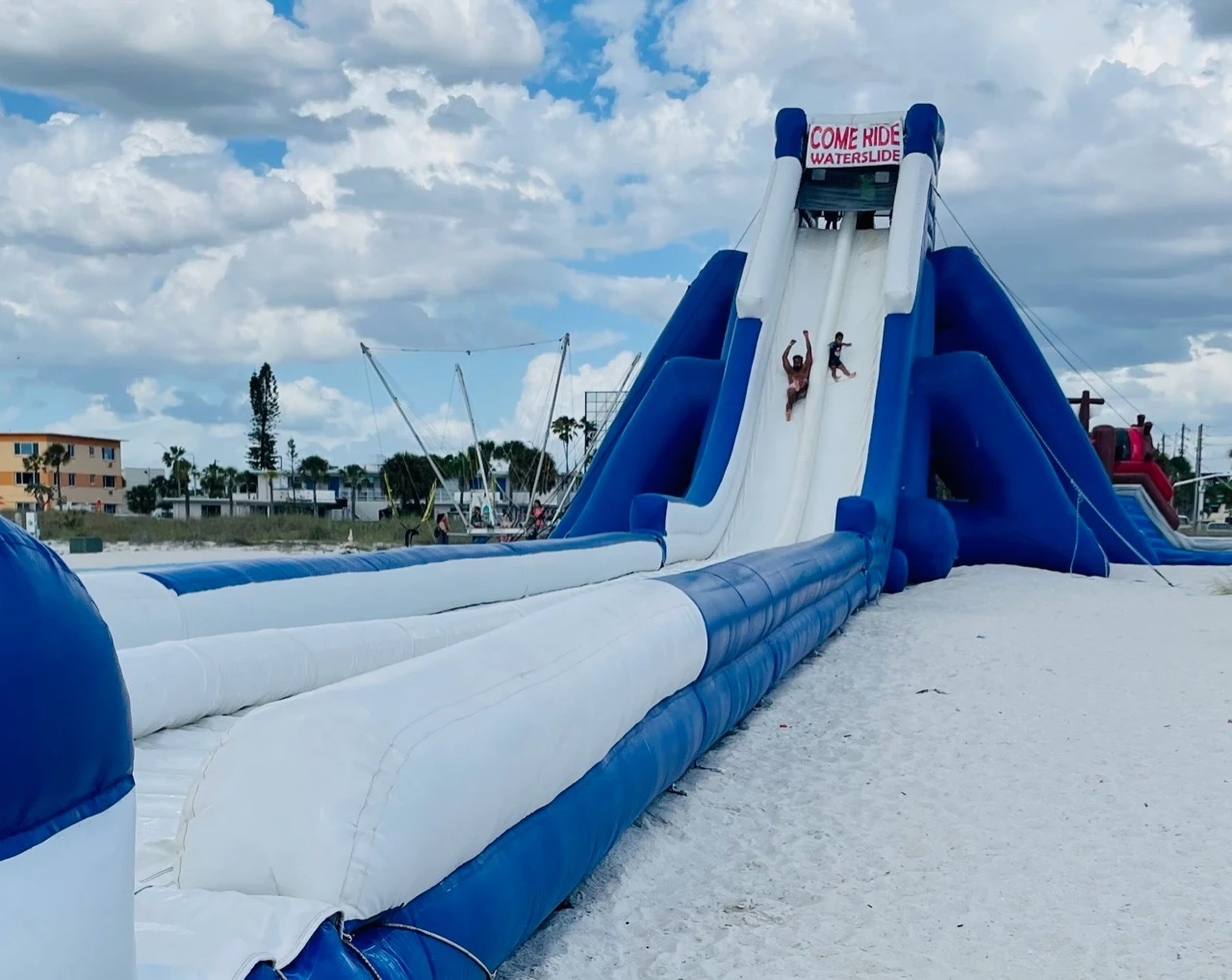 Guests enjoying the Giant Hippo Waterslide on the beach