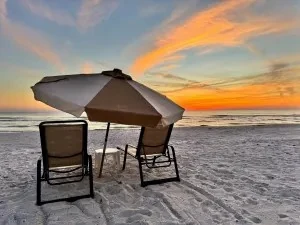 Beach umbrella with two loungers